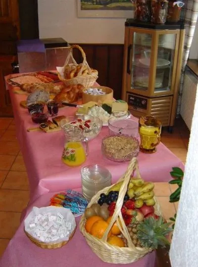 Brunch-Buffet mit Früchtekorb, Süssem und Zopf auf einem Tisch