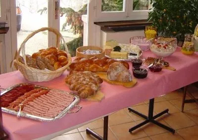 Brunch-Buffet mit Brotkorb, Zopf, Aufschnitt und Käse am Fenster