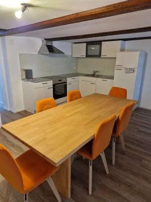 Küche mit Holztisch und orangen Stühlen