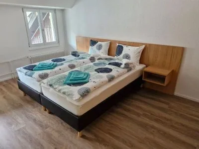 Zweites Gästezimmer mit Doppelbett und Holz-Nachttischen